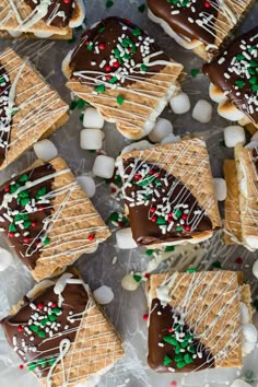 christmas cookies with chocolate and marshmallows are arranged on a sheet of wax paper