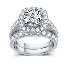 a white gold ring set with diamonds on the band and an engagement ring in the center