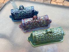 three decorative dishes sitting on top of a table