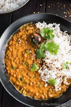 a bowl filled with rice, beans and cilantro on top of a wooden table