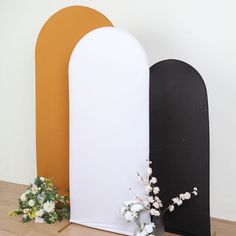 there are two vases with flowers next to each other on the floor near an arch