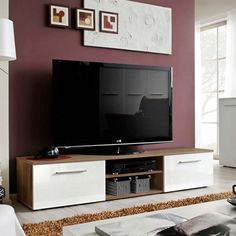 a flat screen tv sitting on top of a wooden entertainment center in a living room