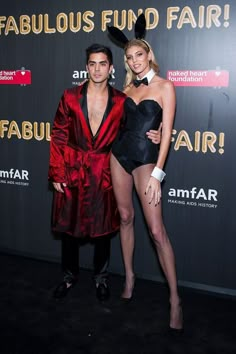 two people standing next to each other in front of a black wall with the words fabulous fund fair on it