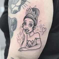 a woman with a tiara on her head is sitting in front of a tattoo