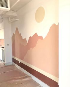 an empty room with mountains painted on the wall