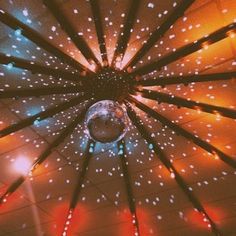 an overhead view of a lit up umbrella with stars on the ceiling and lights all around it