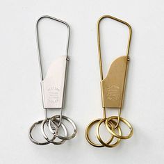 two gold and silver paper clips sitting next to each other