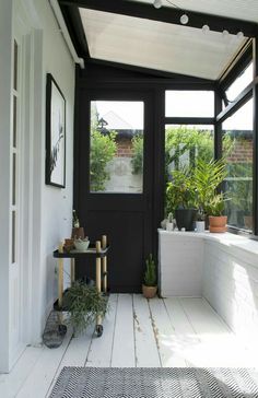 a black and white porch with potted plants