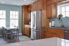 a kitchen with wooden cabinets and stainless steel appliances in the center, along with white counter tops