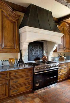 a stove top oven sitting inside of a kitchen next to wooden cabinets and counter tops