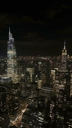 an aerial view of the city at night with skyscrapers lit up in bright lights