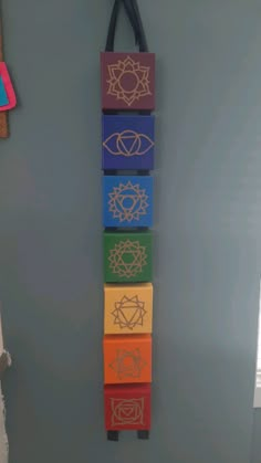 a wall hanging made out of four different colored blocks with an eye on the top