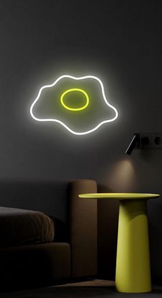 a yellow table sitting in front of a black wall with a neon light on it