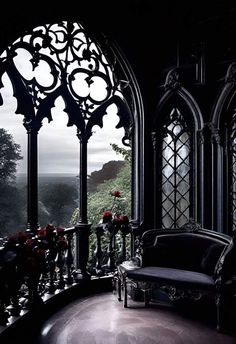 a room with an arched window and some flowers on the table in front of it