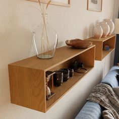 two wooden shelves with vases and other items on them