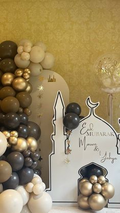 balloons and decorations are on display in front of a wallpapered background with a mosque