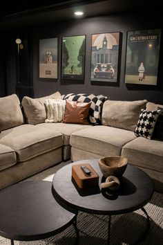 a living room filled with furniture and pictures hanging on the wall above it's coffee table