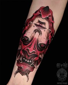 a person with a tattoo on their arm that has a demon face and red hair