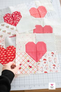 someone is cutting out the heart shapes on a piece of fabric that has been sewn together