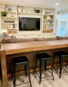 a living room filled with furniture and a flat screen tv mounted to the side of a wall