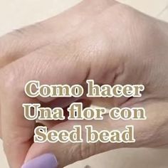 a person with purple nail polish on their nails and the words como hacer unaflor con seed bead