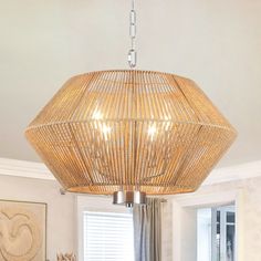 a bamboo chandelier hanging from the ceiling in a living room with white walls