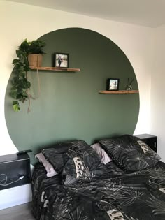 there is a bed with black and white sheets in the room that has green walls