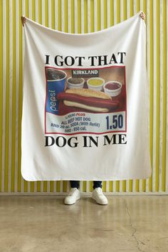 a person holding up a banner with a dog in me advertisement on it