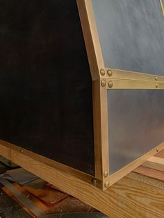 a close up of a wooden frame with metal rivets