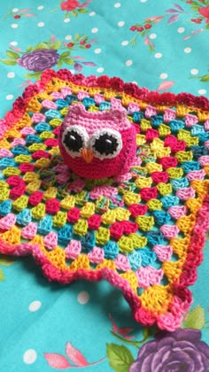 a crocheted owl sitting on top of a blanket