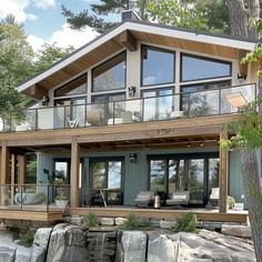 a large house sitting on top of a lush green hillside next to a forest filled with trees