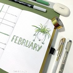 an open notebook with the word february written in green on it next to pens and markers