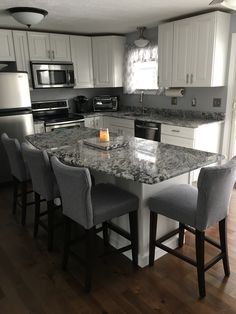 a kitchen with an island, stove and refrigerator