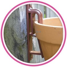 a pink circle with an image of a planter hanging on the side of a wall