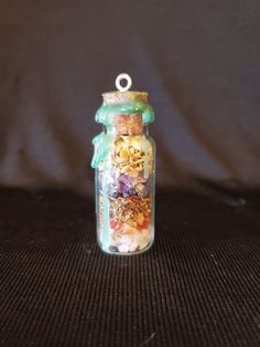 a glass jar filled with lots of different things on top of a black tablecloth