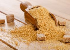 a wooden table topped with lots of brown sugar next to a knife and block of wood