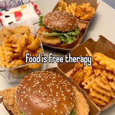 three boxes filled with fries and hamburgers on top of a white table next to each other