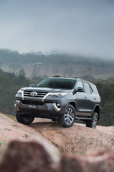 a grey truck parked on top of a rocky hill