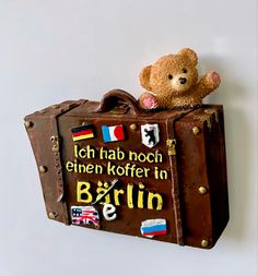 a teddy bear sitting on top of an old suitcase that says, i am not even koffer in berlin