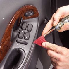 a man is using a brush to clean the inside of a car's door handle