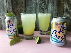 three cans and two glasses filled with limeade