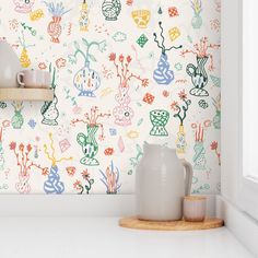 the wallpaper in this kitchen is colorful and has various designs on it, as well as vases