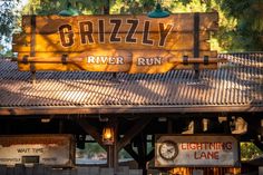 the sign for grizzly river run on top of a building in front of trees