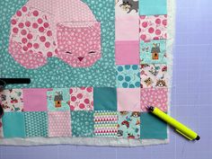 a piece of fabric with some scissors on top of it next to a patchwork quilt