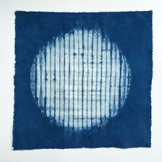 a blue and white painting with lines on it's surface in the shape of a circle