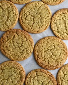 several cookies are lined up on a sheet of wax paper and ready to be baked