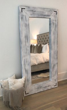 a large mirror sitting on top of a wooden floor