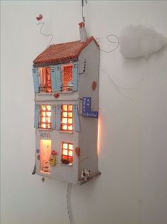 a doll house is lit up in the shape of a building