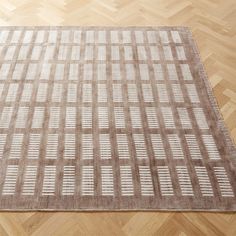 an area rug on the floor with wooden floors and parquets in the background