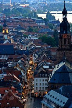 an aerial view of a city with tall buildings and steeples at dusk, in the foreground is a large body of water